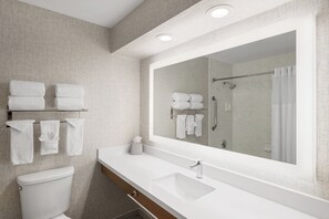 A modern bathroom with a white sink, a large mirror, and a glass shower enclosure. - Holiday Inn Express San Diego - SeaWorld Area by IHG (San Diego)