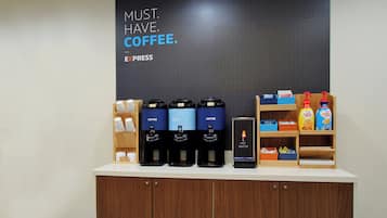 Una estación de café con varios dispensadores, un letrero que dice 'MUST HAVE COFFEE' y diversos productos de café.