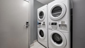 A laundry room with two stacked front-loading washing machines and a closed door.