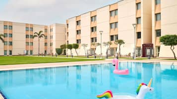 Una piscina al aire libre, sillones reclinables de piscina