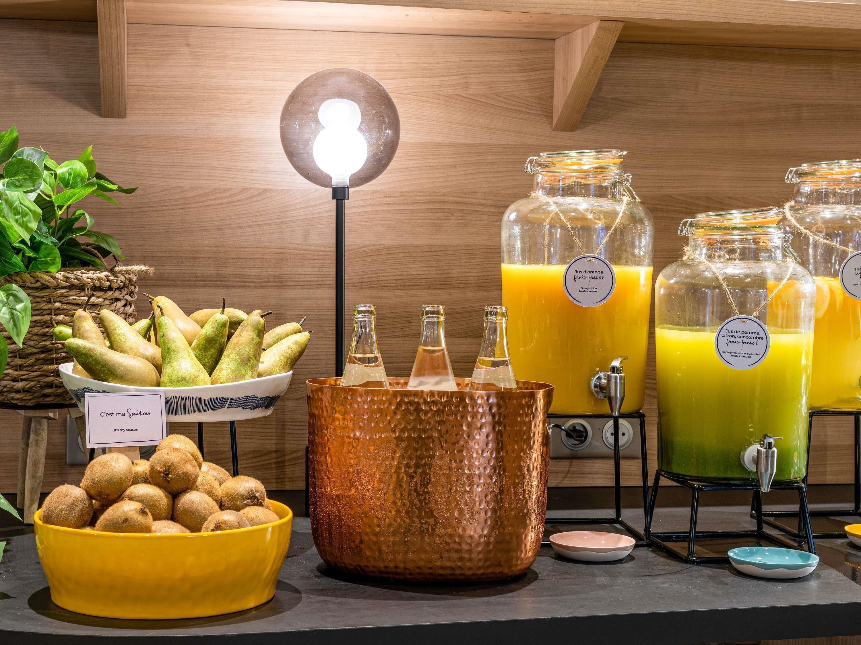 Een buffetopstelling met fruit, drankjes en een bord waarop staat dat het seizoensgebonden is.