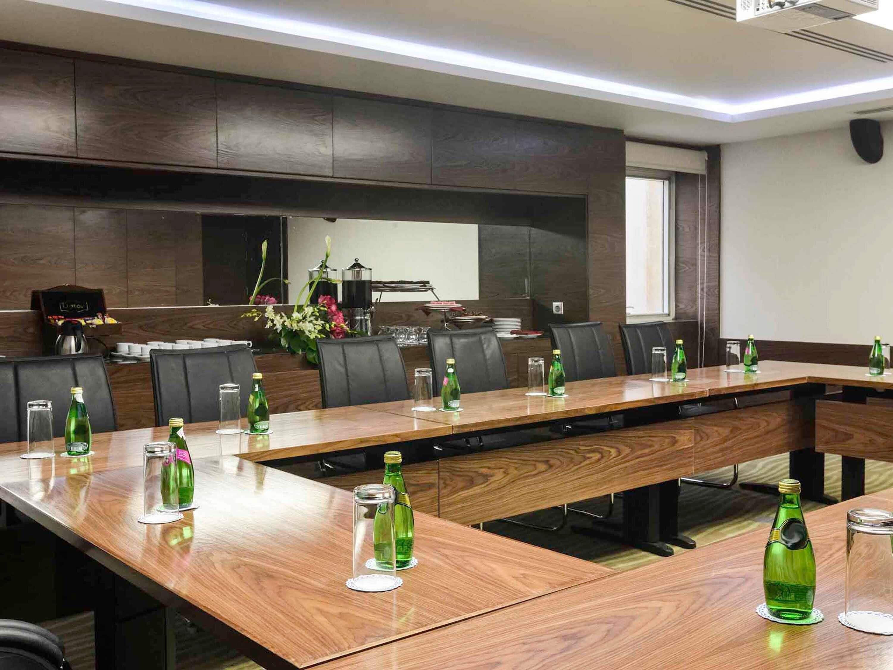 A conference room with a long table, chairs, and a coffee machine.
