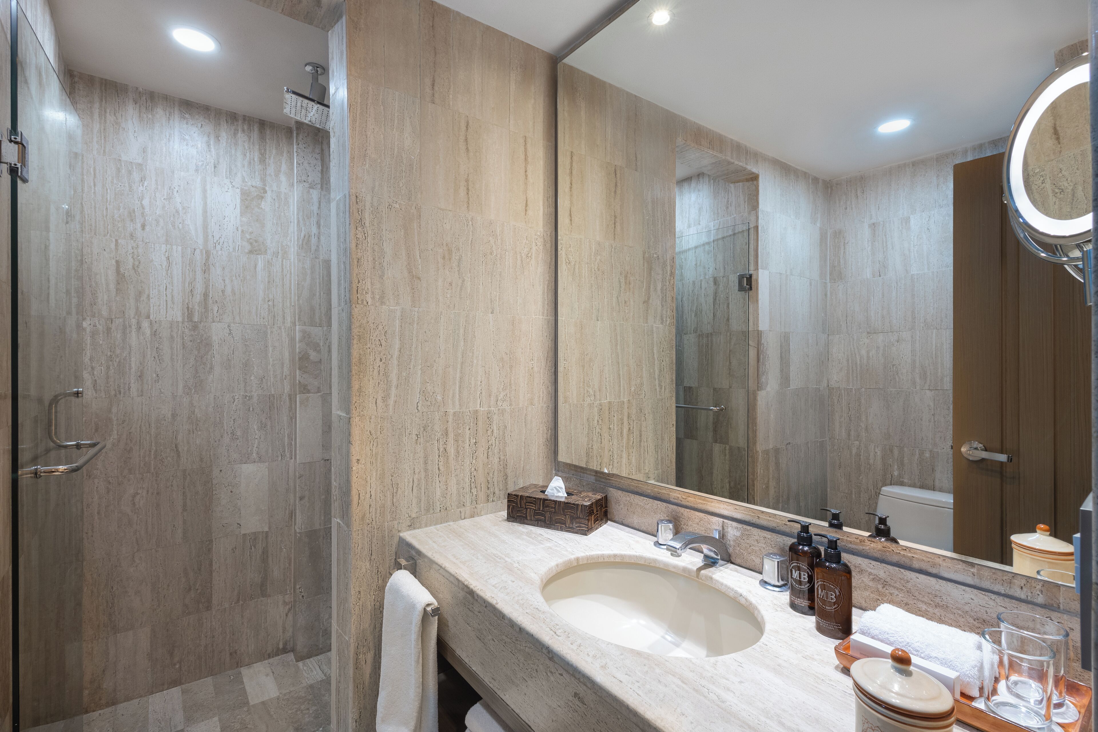 Une salle de bain moderne avec un grand lavabo, un miroir et une douche.