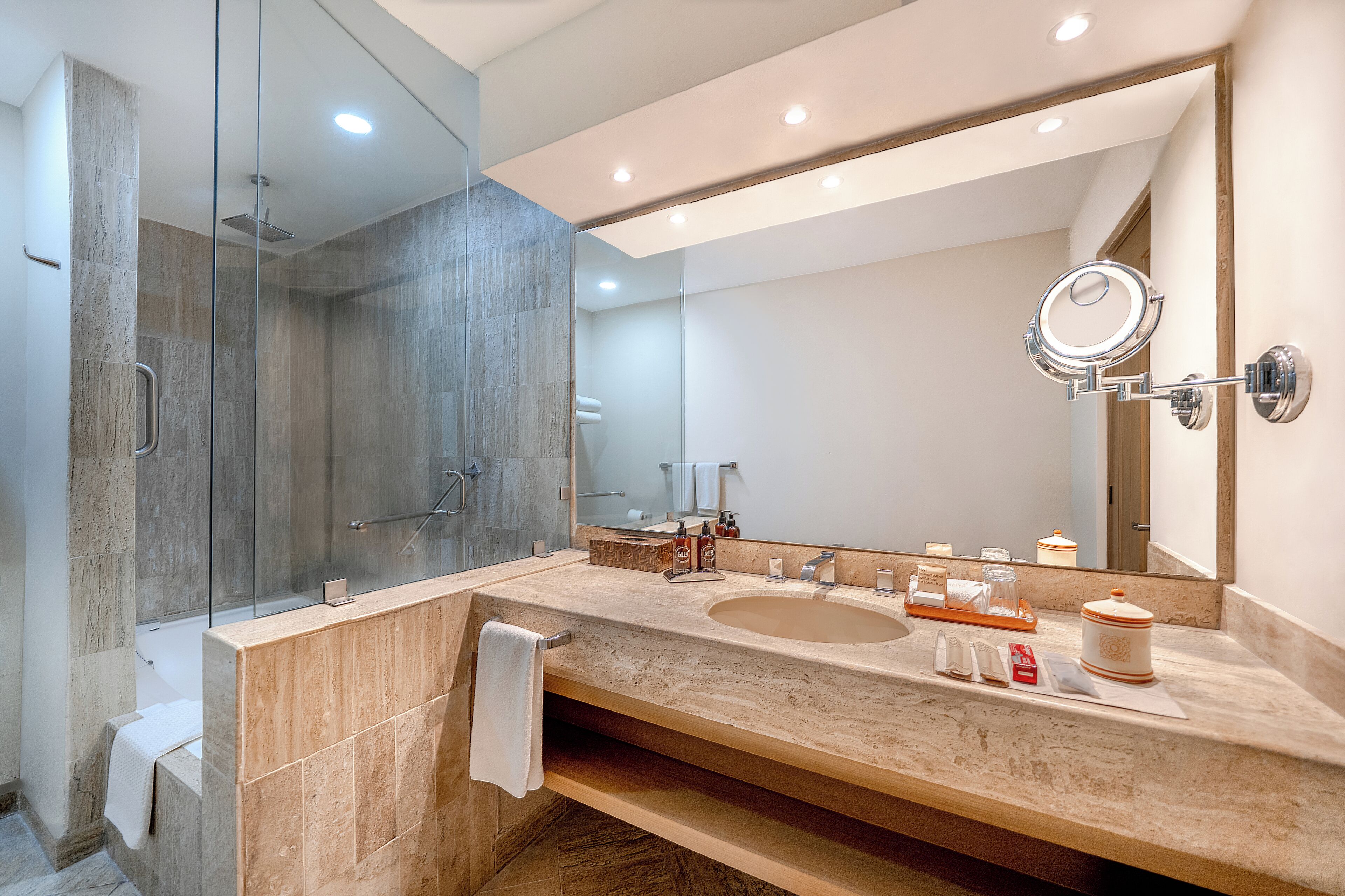 Un baño moderno con lavamanos doble, cabina de ducha de vidrio y un espejo grande.