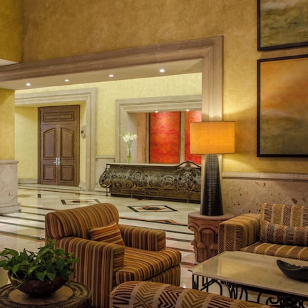 A lobby with a marble floor, a sofa set, a lamp, and a reception desk.