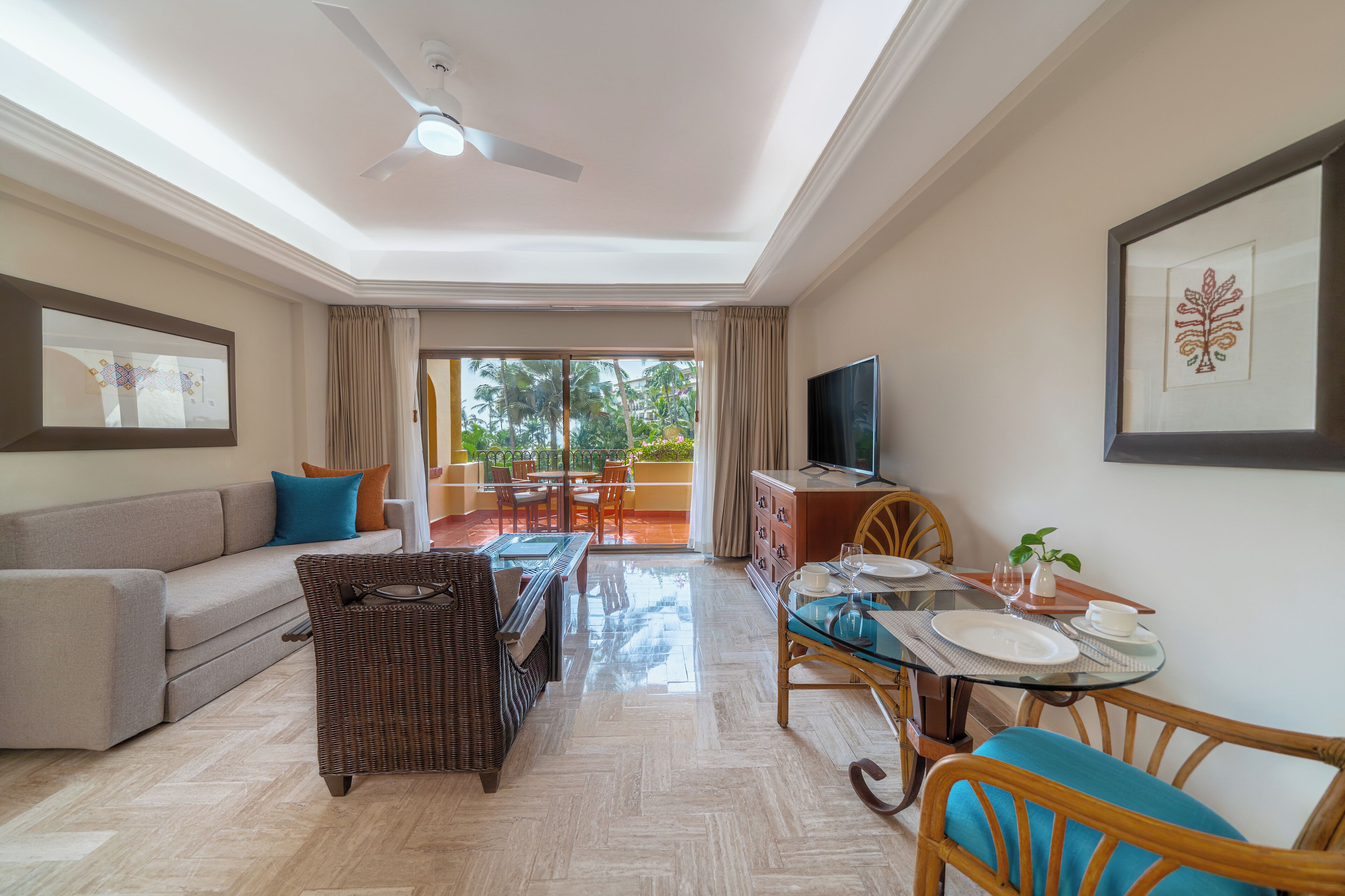 A spacious living area with a sofa, a dining table, and a television.
