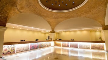 Um hall amplo com teto alto e abobadado e um balcão de recepção extenso.