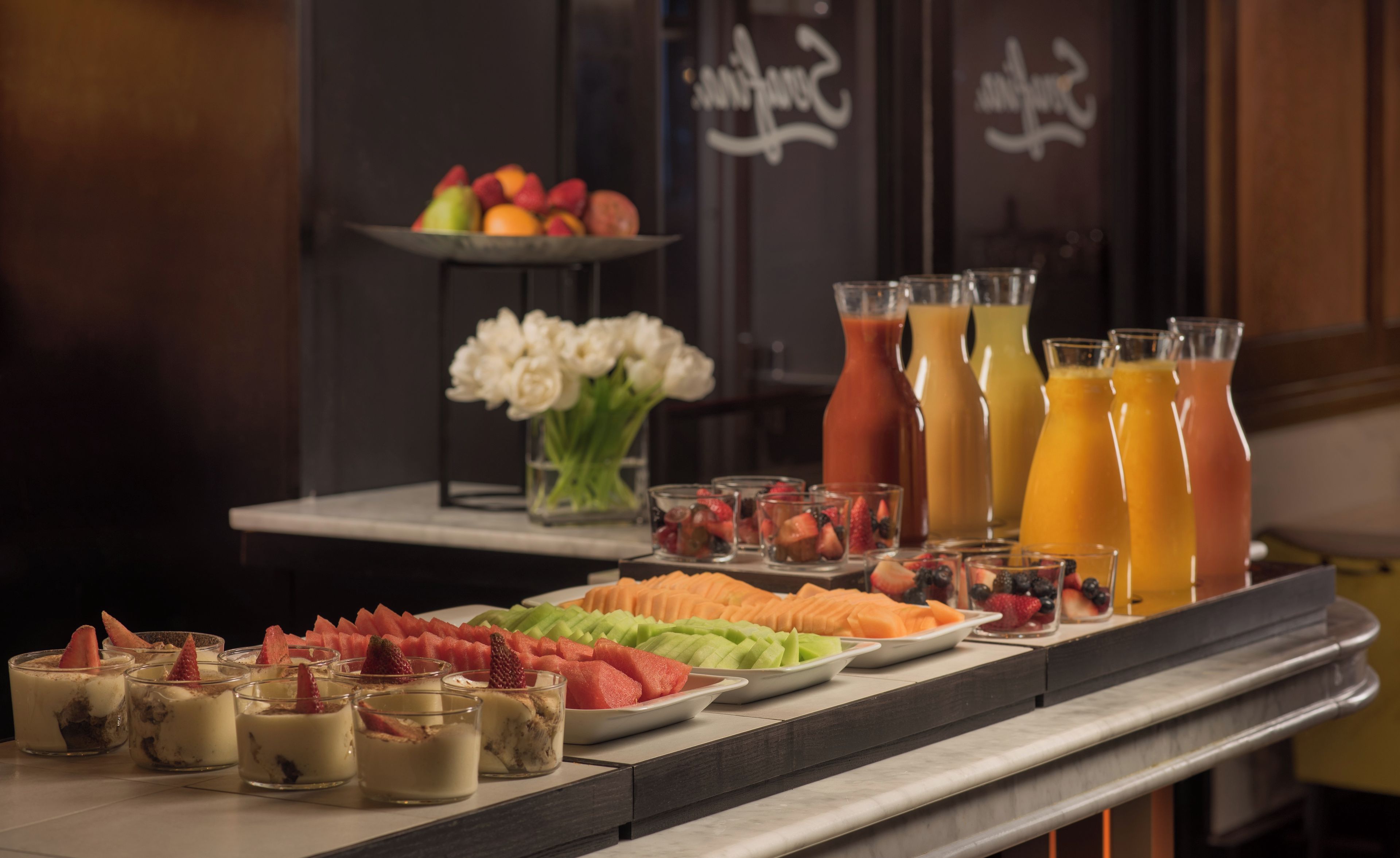 A buffet table with various food items and beverages.