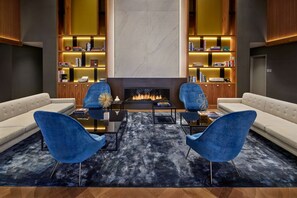 A modern living room with a fireplace, two sofas, and a bookshelf. - NH Collection New York Madison Avenue (New York)