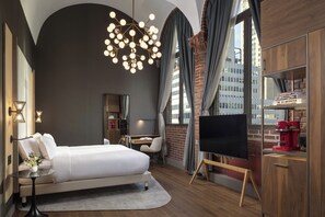 A modern hotel room with a bed, desk, TV, and large windows. - NH Collection New York Madison Avenue (New York)