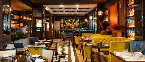 A restaurant interior with tables, chairs, and a bar area.