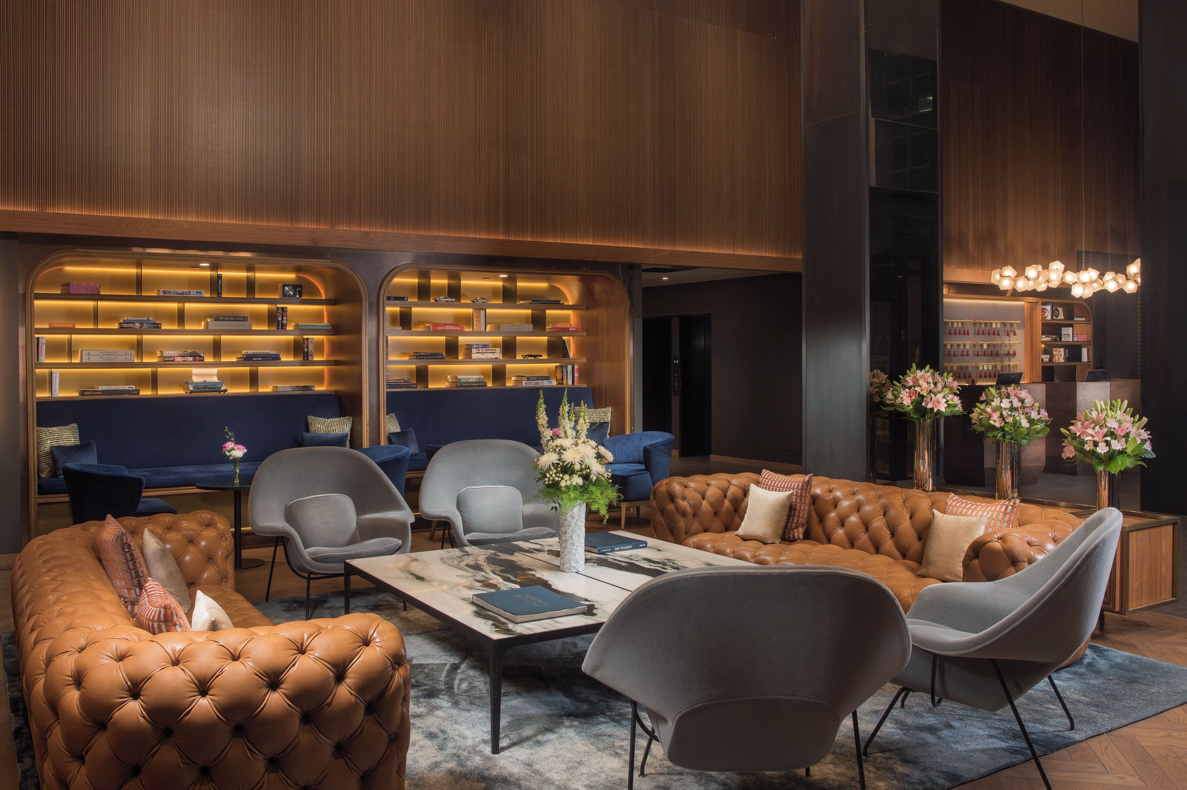 Een moderne zithoek met leren banken, fauteuils en een salontafel.