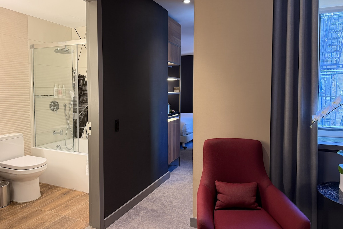 A modern bathroom with a glass shower enclosure, a toilet, and a bathtub.