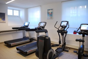 A gym with treadmills, elliptical machines, and stationary bikes.