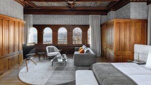 A spacious room with a large window, a sofa, a TV, and a bed. - Château d'Ouchy (Lausanne)