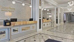 A hotel reception area with a brick wall, a reception desk, and a chandelier. - Club Wyndham Canterbury (San Francisco)