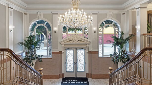 A grand lobby with a chandelier, arched windows, and a 'CLUB WYNDHAM' doormat. - Club Wyndham Canterbury (San Francisco)