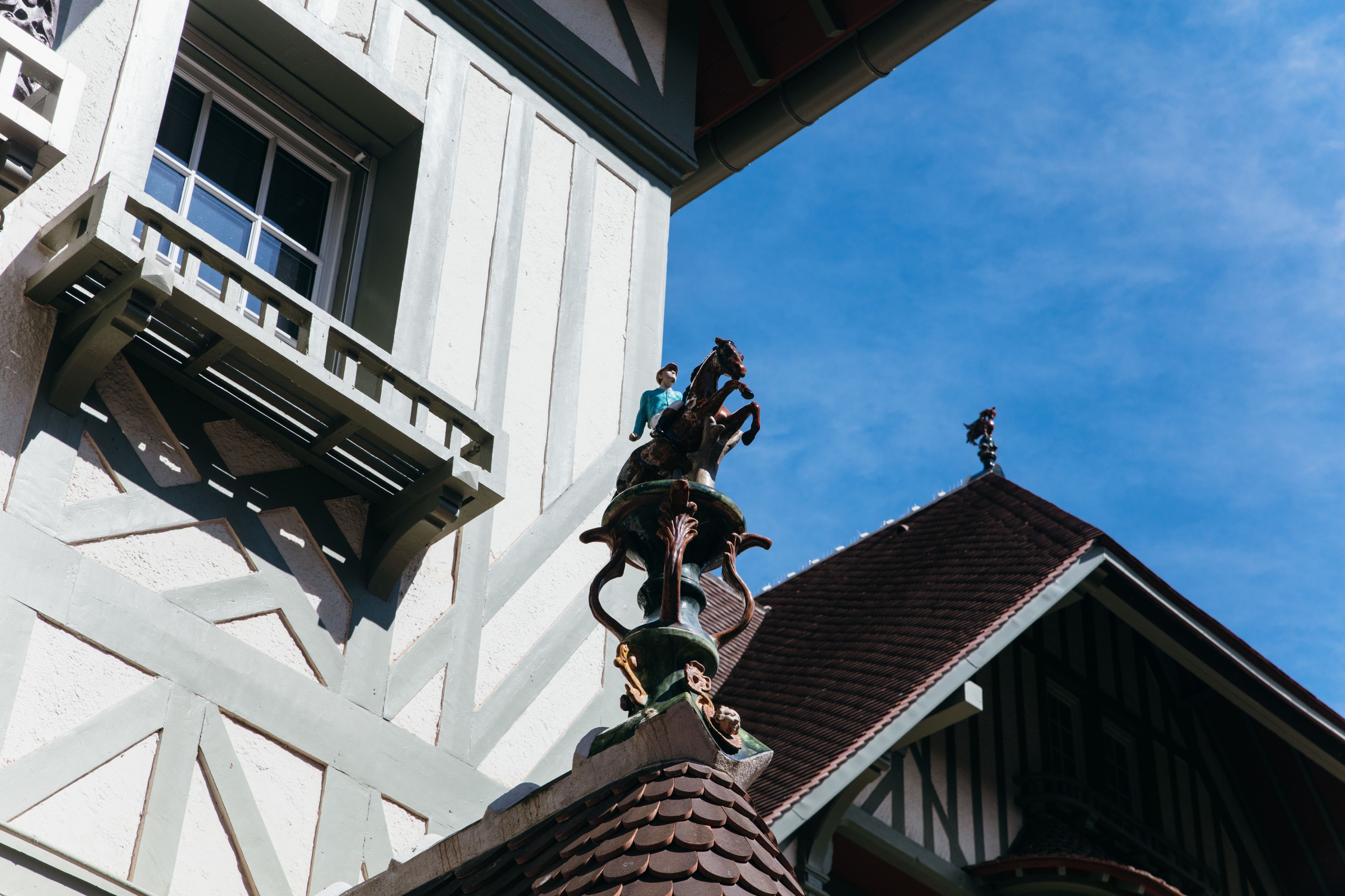 A building with a balcony and a decorative crest on the roof.