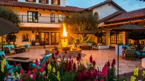 A courtyard with a fire feature, outdoor seating, and a variety of flowers. - Omni Rancho Las Palmas Resort & Spa (Rancho Mirage)
