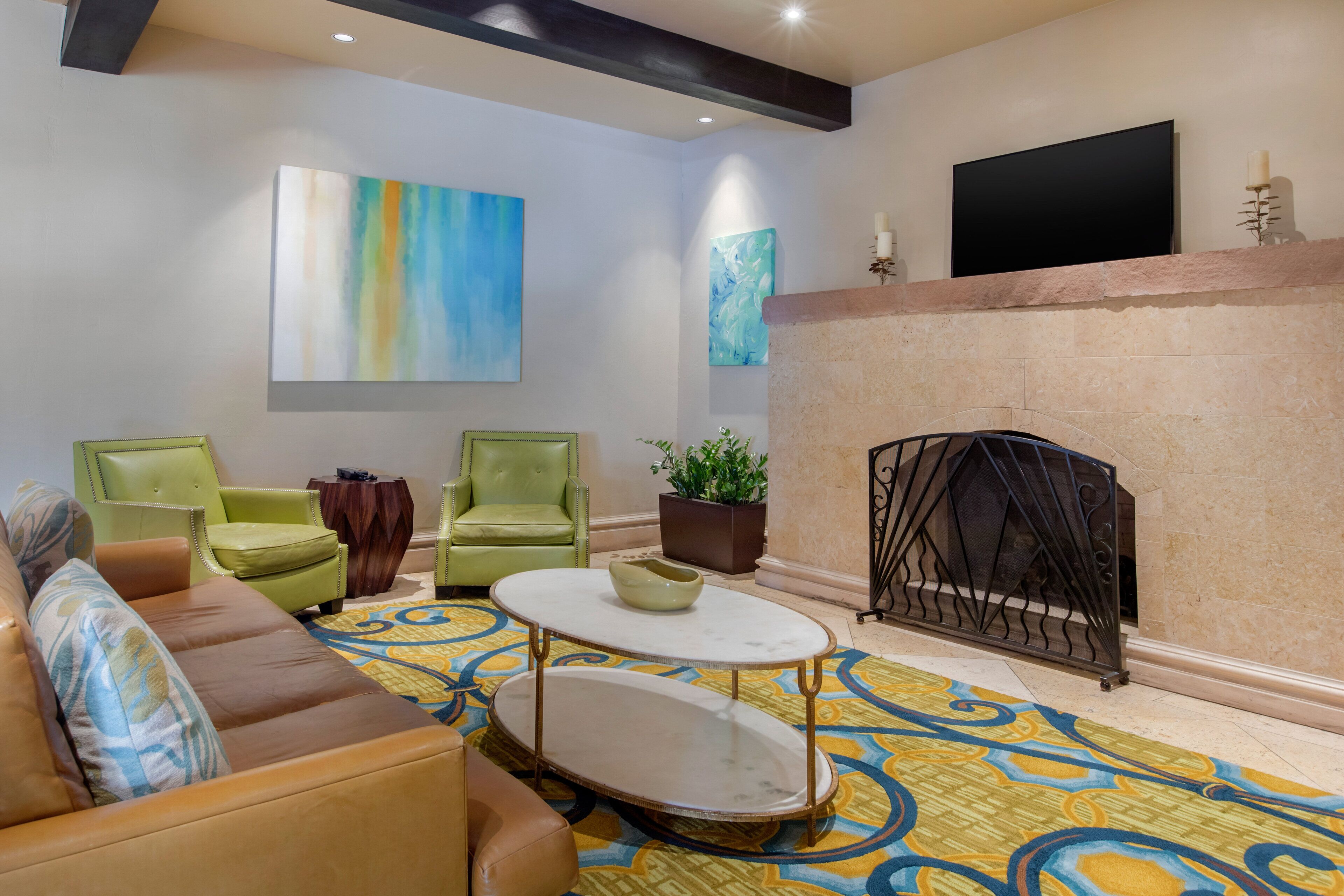 A living room with a sofa, two armchairs, a coffee table, and a fireplace.