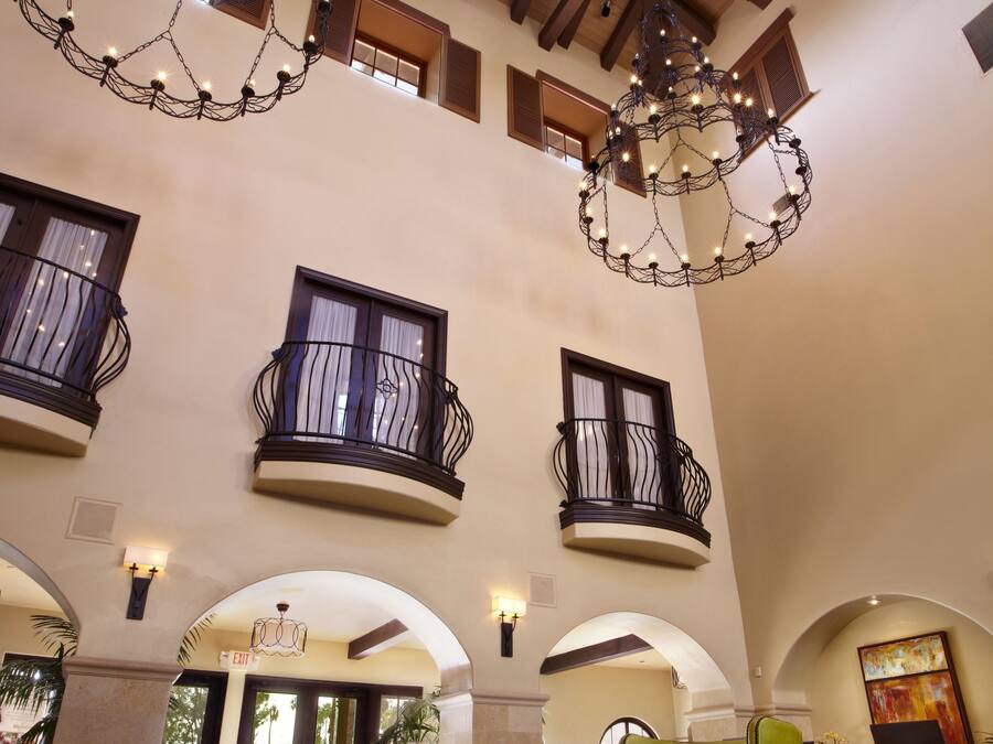 A spacious lobby with high ceilings, a chandelier, and a patterned carpet.