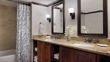 A bathroom with a double sink, a large mirror, a towel rack, and a shower curtain.