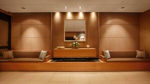 A modern lobby with a reception desk, seating area, and a large mirror. - Inn By The Sea La Jolla (La Jolla)