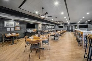 A spacious restaurant with multiple dining tables and chairs, ceiling fans, and wall-mounted TVs. - Best Western Plus Hilltop Inn (Redding)