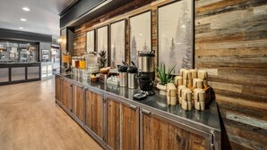 A modern kitchen with wooden cabinets, a stainless steel countertop, and various kitchen appliances. - Best Western Plus Hilltop Inn (Redding)