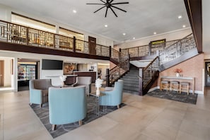 A spacious lobby with a staircase, seating area, and a reception desk. - Best Western Plus Hilltop Inn (Redding)