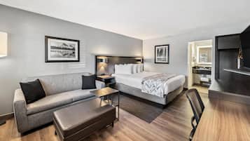 Et moderne hotelværelse med seng, sofa og skrivebord.
