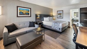 A modern hotel room with a sofa, a bed, a desk, and a TV. - Best Western Plus Hilltop Inn (Redding)