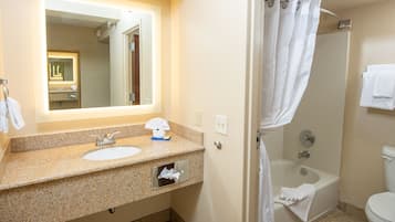 Une salle de bain avec un lavabo, un miroir et une douche.