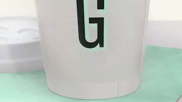 A white cup with a black 'G' logo, placed on a green napkin.