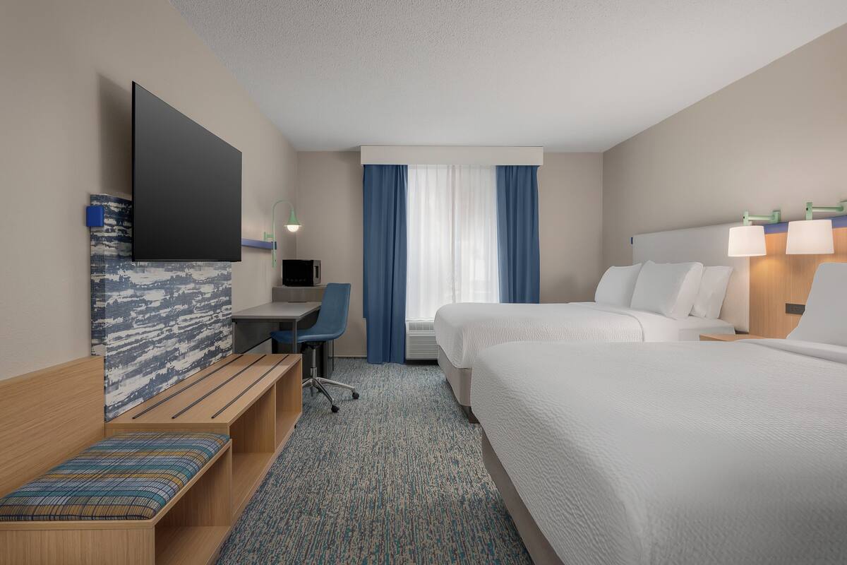 Une chambre d’hôtel équipée d’un lit, d’un bureau, d’une chaise et d’une télévision.
