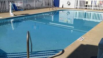 Relax by the rectangular pool surrounded by a white picket fence.