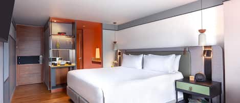 Una habitación de hotel moderna con una cama grande, mesitas de noche, un armario y un baño.
