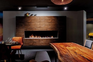 Un interior moderno con chimenea, una mesa de comedor y una zona de estar.