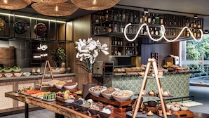Montaje de bufé con diferentes opciones de comida y una barra con botellas de licor.
