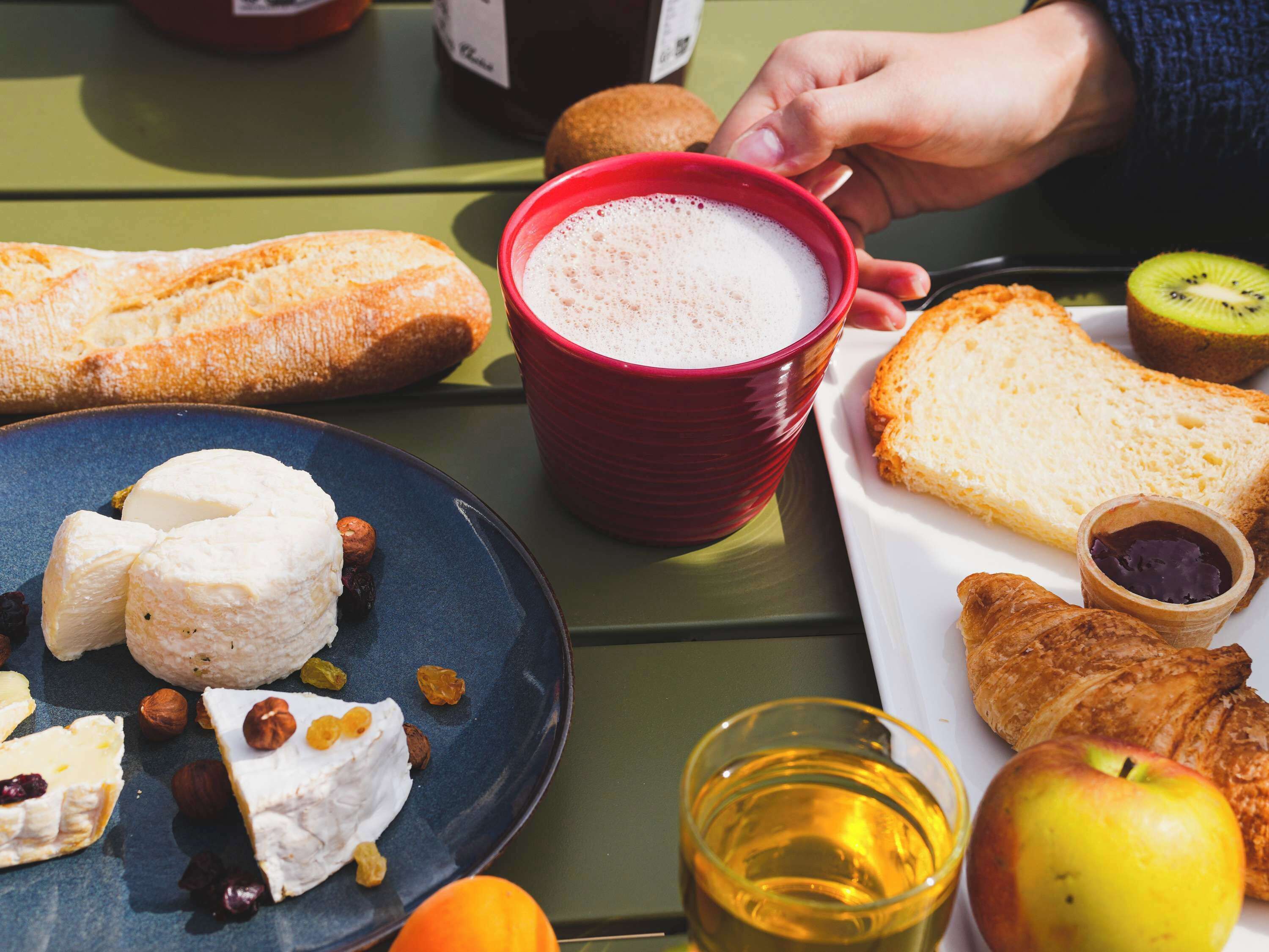 A table with a variety of foods including bread, cheese, and fruits.