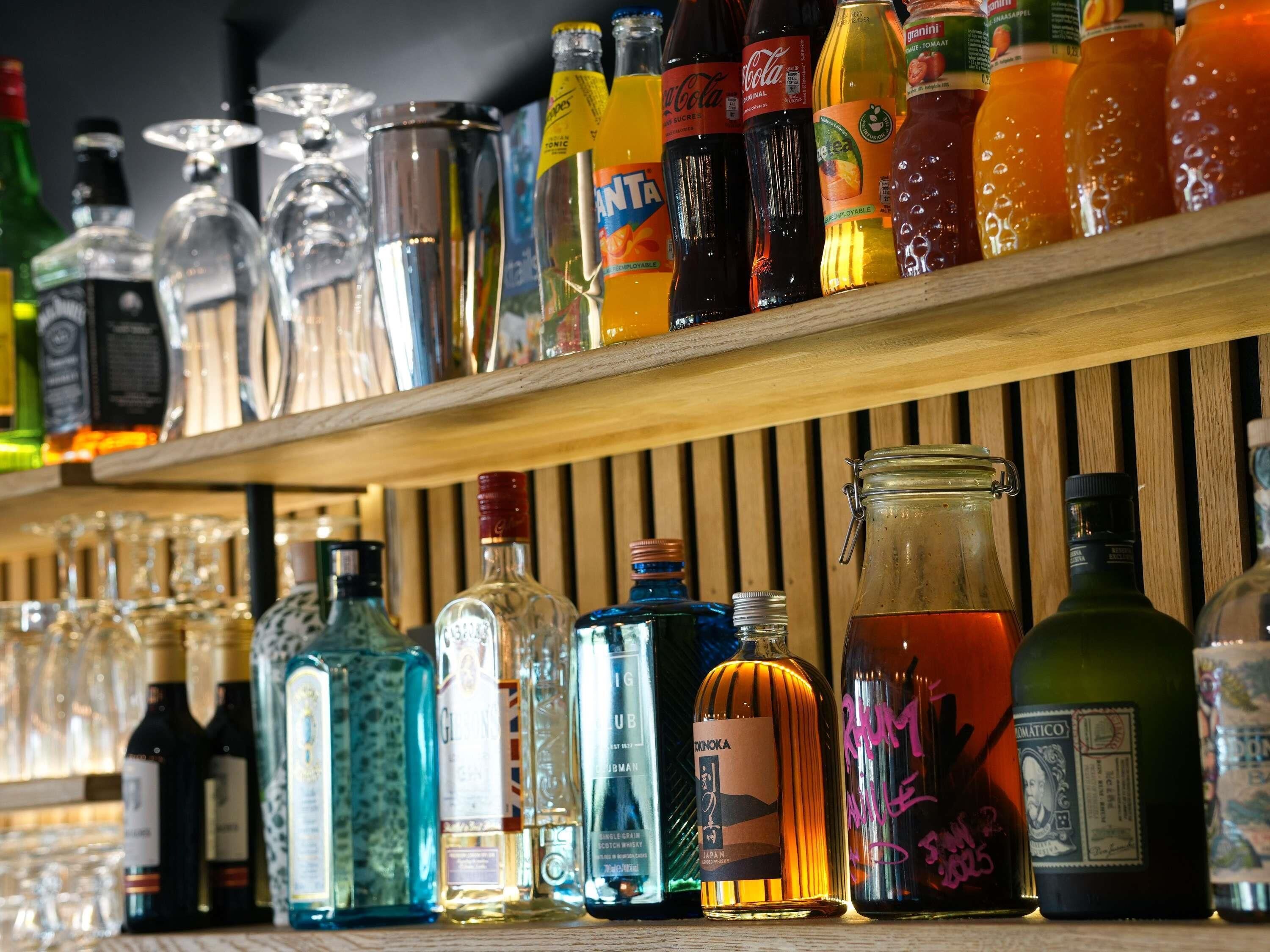 A bar with various bottles of alcohol and glasses.