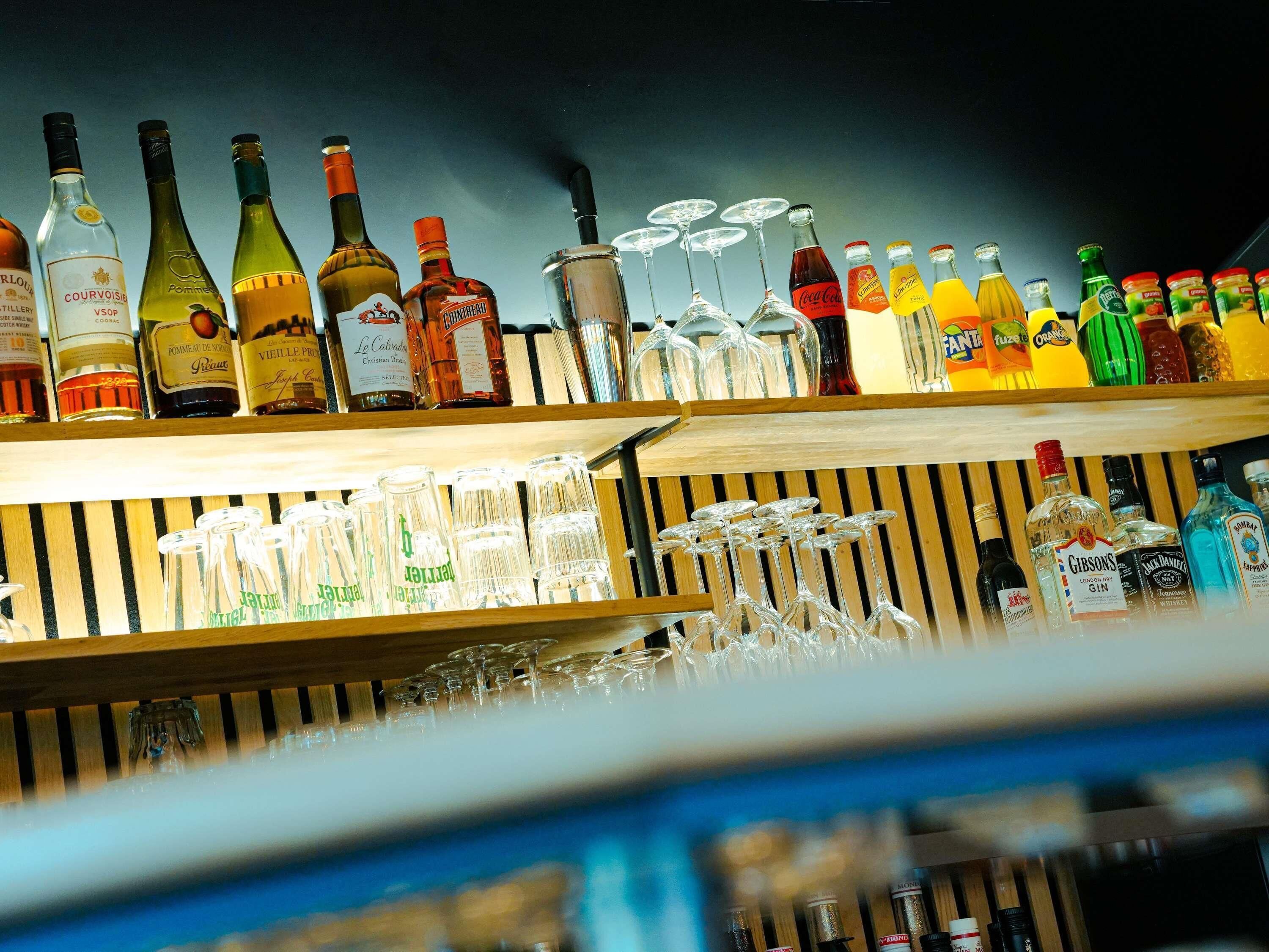 A bar area with various liquor bottles and glasses.