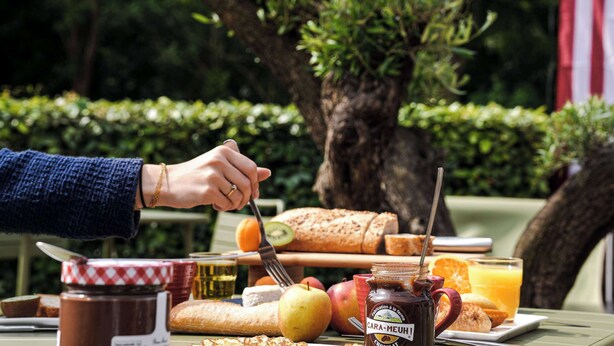 A breakfast setting with bread, fruits, and a jar of honey. - ibis Caen Porte d'Angleterre (Herouville-Saint-Clair)