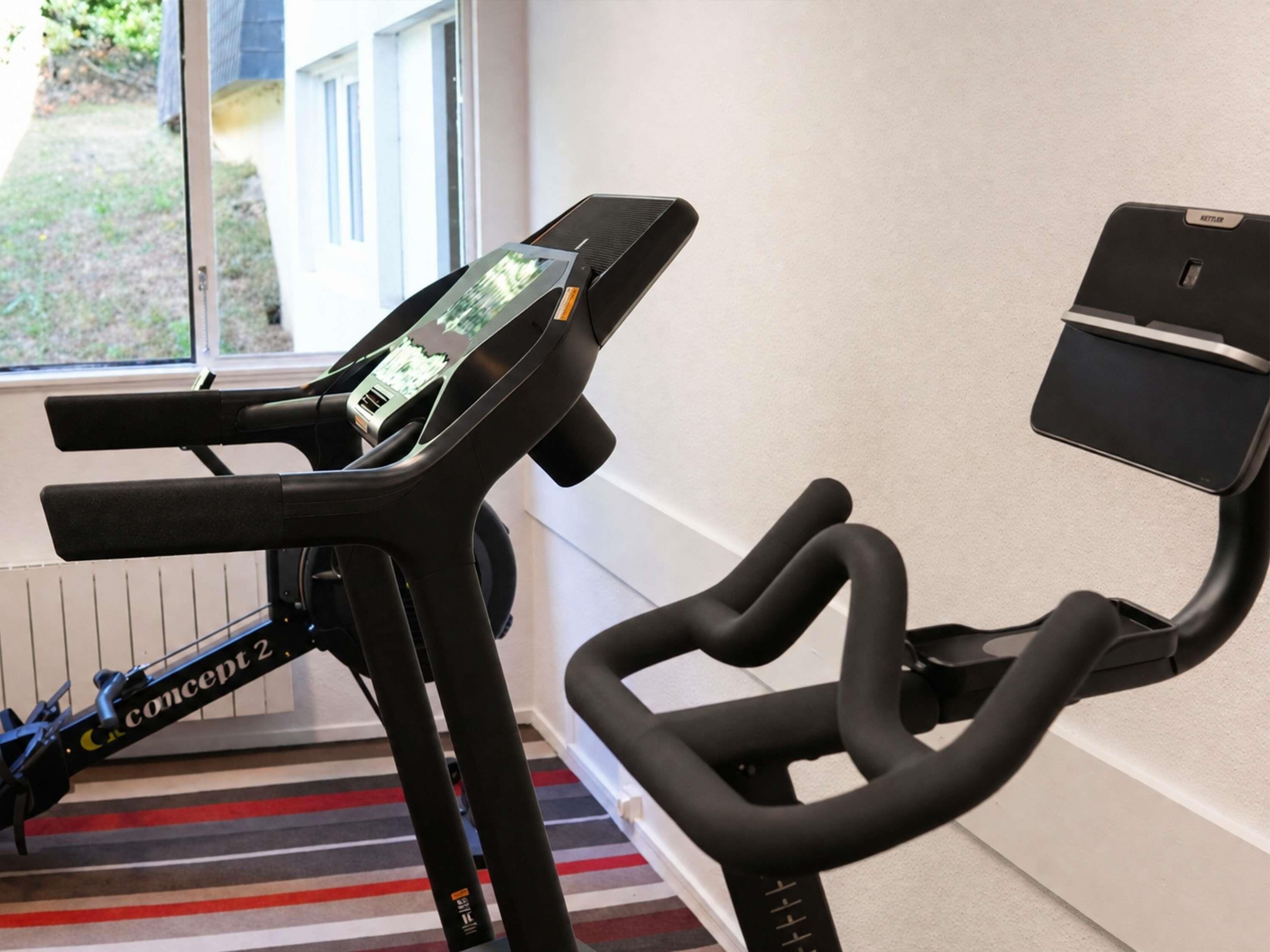 A stationary bike with a digital display and a handlebar.