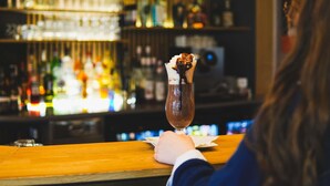 A bar with a variety of bottles and a dessert on the counter. - ibis Caen Porte d'Angleterre (Herouville-Saint-Clair)