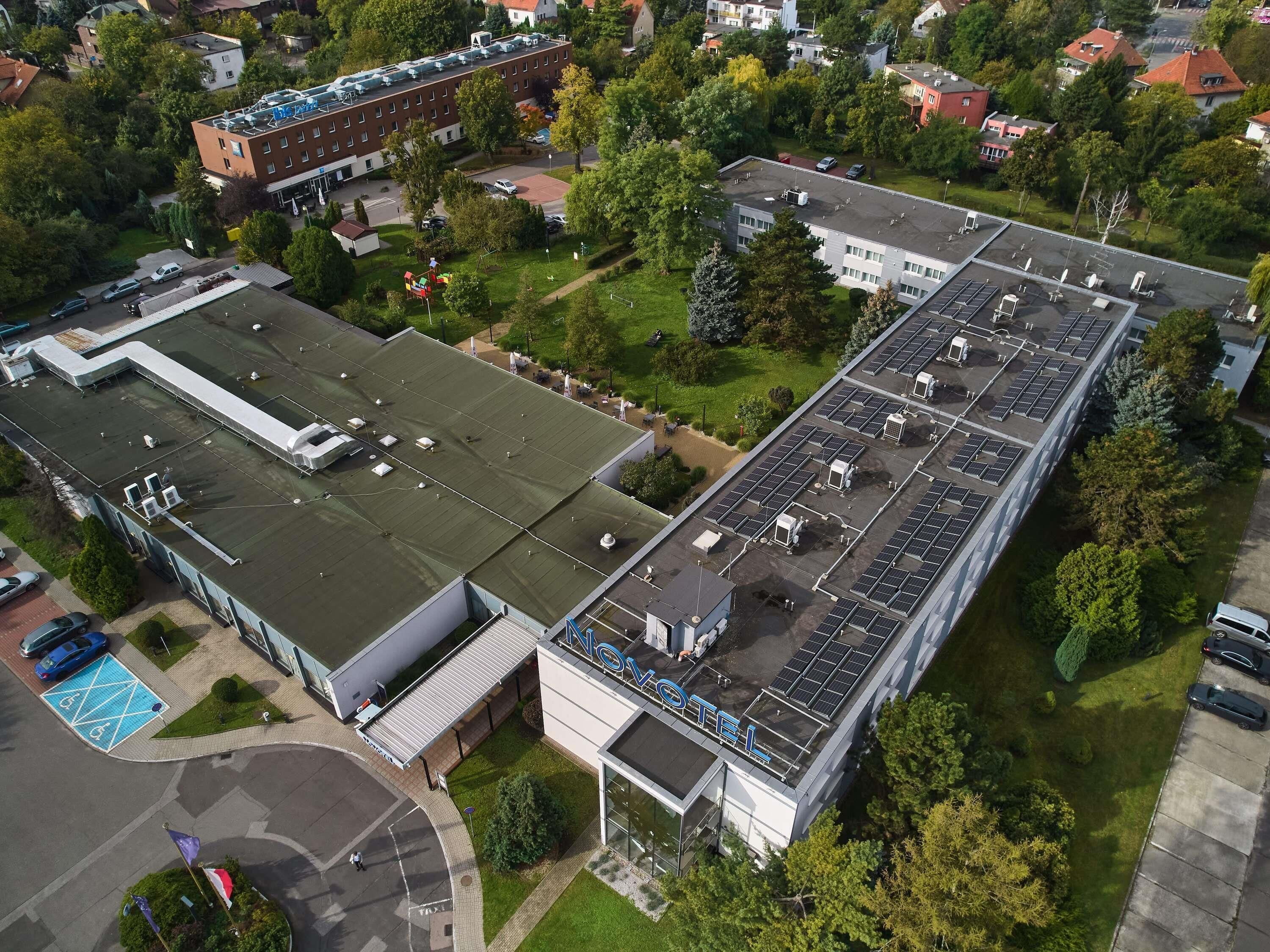 Un grande edificio con diversi piani, un parcheggio e una piscina.