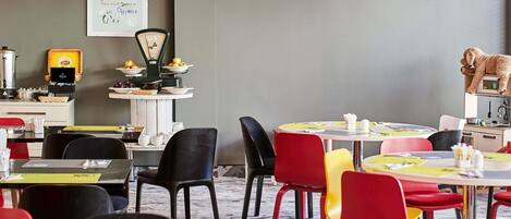 A restaurant interior with tables, chairs, a coffee machine, and a wall sign.