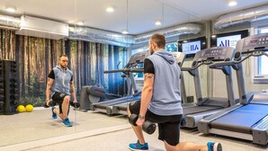 A gym with treadmills, weights, and a large mirror.