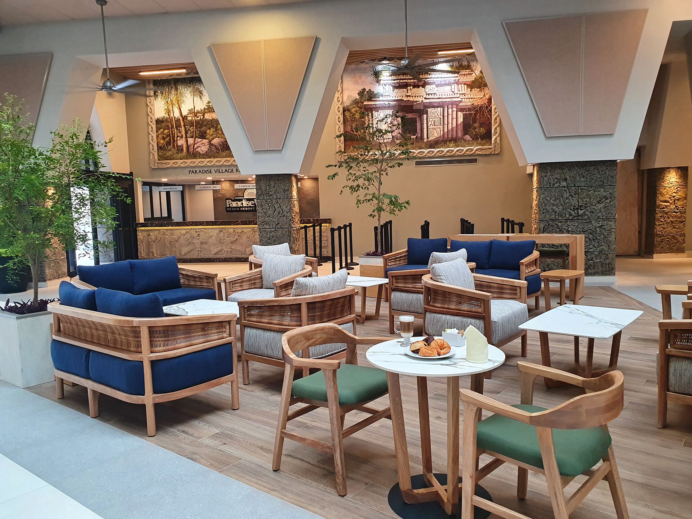 Un espace de détente moderne, doté de meubles en bois, d’une grande table à manger et d’une fresque représentant un temple.