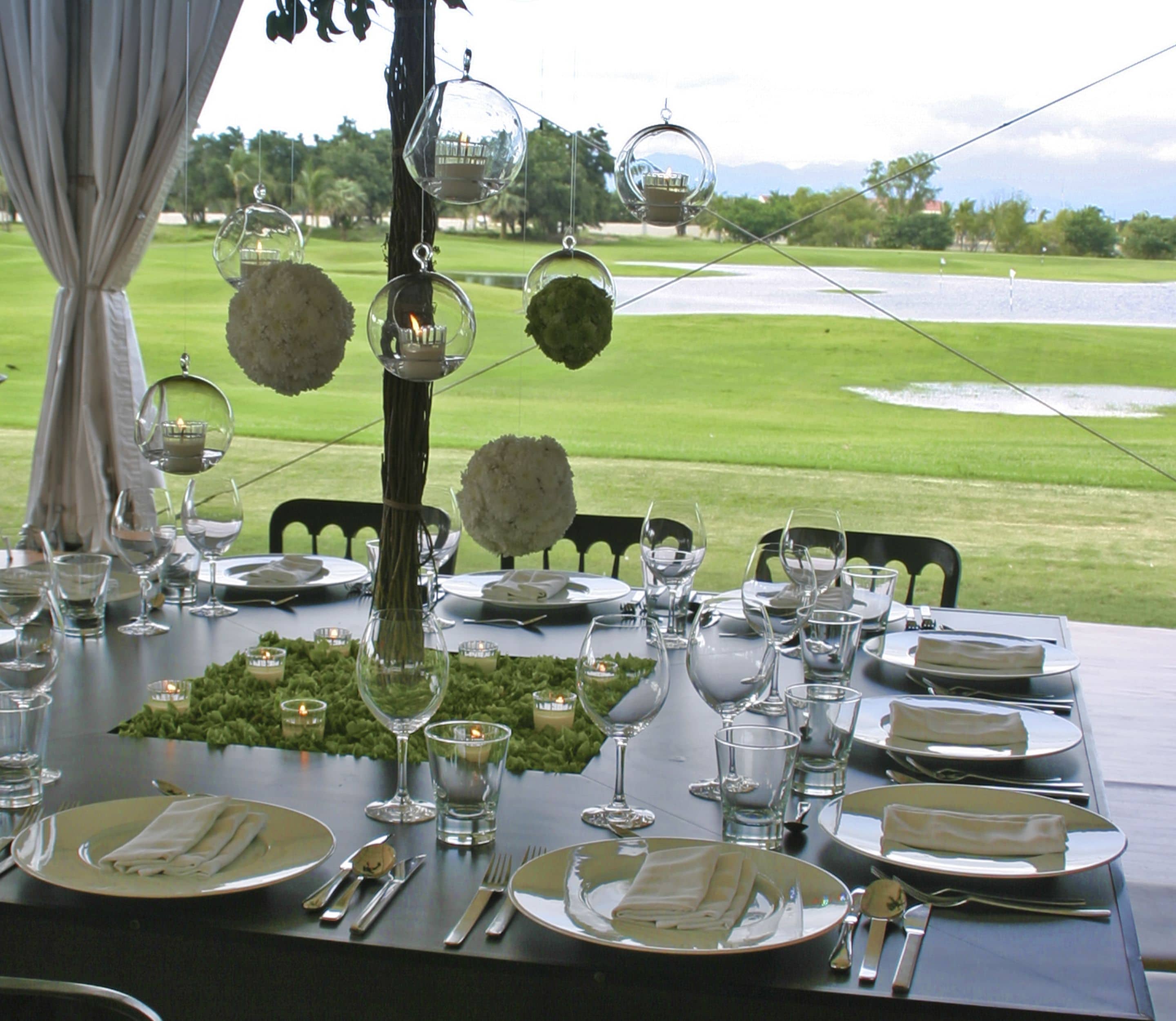 A table set for a meal with a view of a golf course.